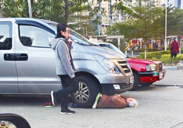 ■捱撞老婦雙腳捲入車底;旁為涉事客貨車司機。讀者提供圖片■救護員將郭婆婆的一袋蔬菜帶上白車內。 ■捱撞老婦雙腳捲入車底;旁為涉事客貨車司機。讀者提供圖片■救護員將郭婆婆的一袋蔬菜帶上白車內。