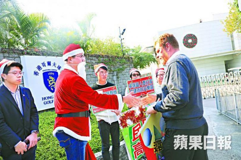 ■尹兆堅昨化身聖誕老人，向香港哥爾夫球會代表送上「還地於民聖誕卡」。王心義攝