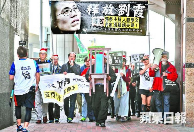 ■遊行隊伍昨手持標語及空凳到中聯辦,要求中共還劉霞自由及釋放維權人士。易仰民攝 ■遊行隊伍昨手持標語及空凳到中聯辦,要求中共還劉霞自由及釋放維權人士。易仰民攝