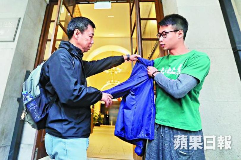 ■梁曉暘(右)獲准保釋後,梁父送上衣物防兒子着涼。 ■梁曉暘(右)獲准保釋後,梁父送上衣物防兒子着涼。