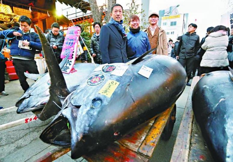■山口幸隆(中)跟投得的「日本一」合照。路透社 ■山口幸隆(中)跟投得的「日本一」合照。路透社