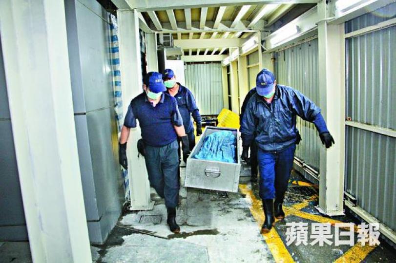 ■女童遺體由仵工運走。 ■女童遺體由仵工運走。