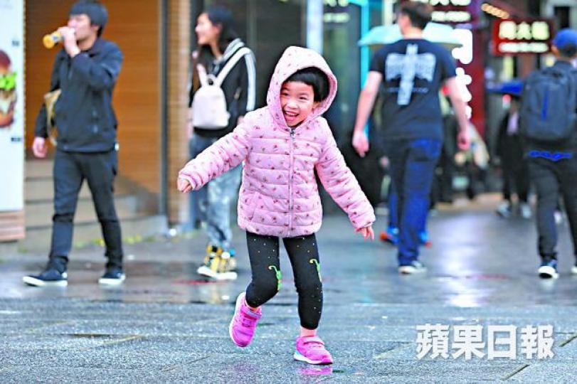 ■昨顯著轉冷,小朋友無懼風雨在街上感受寒冬氣氛。王心義攝 ■昨顯著轉冷,小朋友無懼風雨在街上感受寒冬氣氛。王心義攝
