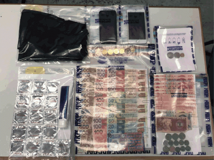 ■警員在掃黃行動中撿獲避孕套、現金及手機等證物。警方提供圖片 ■警員在掃黃行動中撿獲避孕套、現金及手機等證物。警方提供圖片