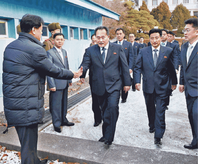 ■李善權(中)率領北韓代表團徒步跨越軍事分界線,獲南韓官員迎接。路透社 ■李善權(中)率領北韓代表團徒步跨越軍事分界線,獲南韓官員迎接。路透社
