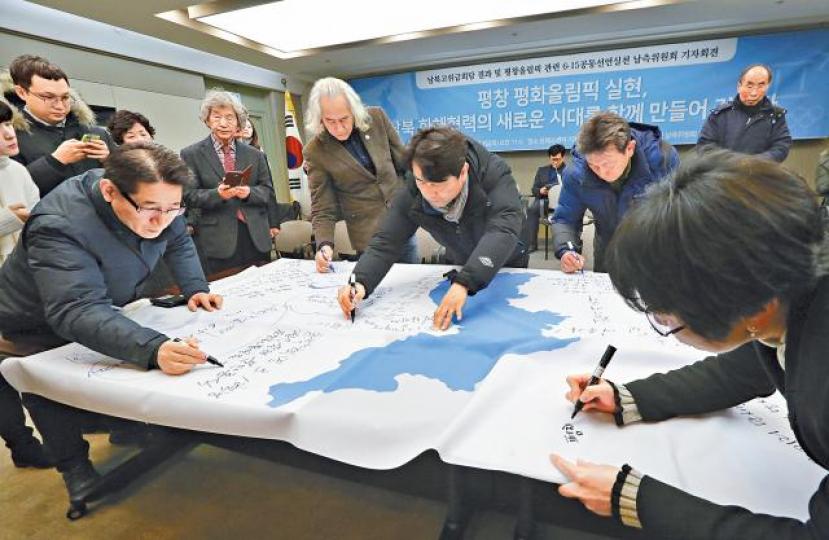 ■南韓有民間組織昨宣佈計劃組建兩韓聯合啦啦隊,組織成員在「統一旗」上寫下祝願半島統一的訊息。美聯社 ■南韓有民間組織昨宣佈計劃組建兩韓聯合啦啦隊,組織成員在「統一旗」上寫下祝願半島統一的訊息。美聯社