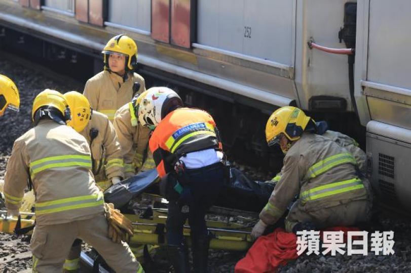 ■消防員昨趕到九龍塘站，在列車車底救起跳軌男子，惟事主當場死亡。梁瑞帆攝
