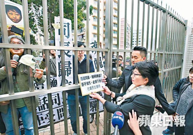 ■鄭若驊受訪後,隔着鐵閘接過社民連請願信。黃耀興攝 ■鄭若驊受訪後,隔着鐵閘接過社民連請願信。黃耀興攝