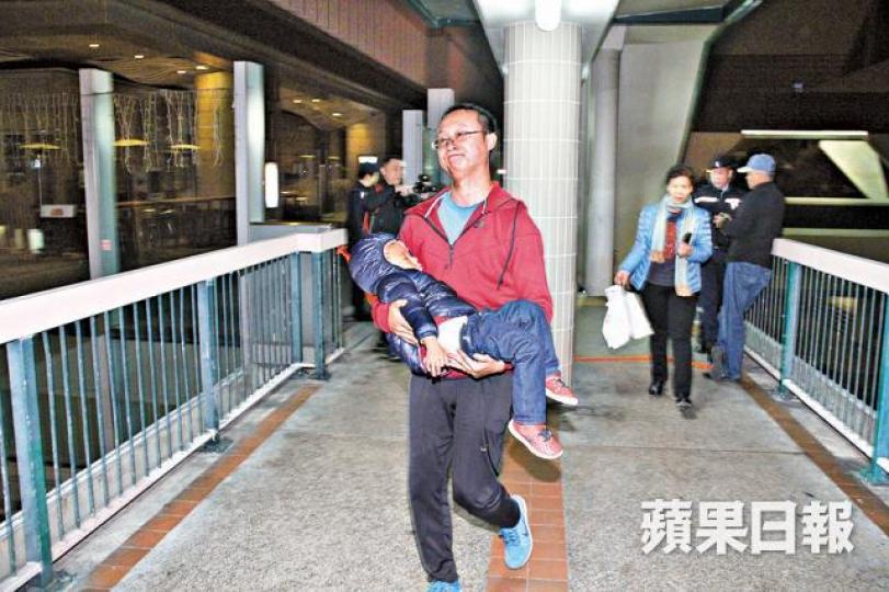 ■有旅客因封路不能返酒店,抱着小孩離開。唐家輝攝 ■有旅客因封路不能返酒店,抱着小孩離開。唐家輝攝