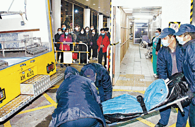 ■貨車司機猝死,10多名家屬目送仵工移走死者遺體。唐家輝攝 ■貨車司機猝死,10多名家屬目送仵工移走死者遺體。唐家輝攝