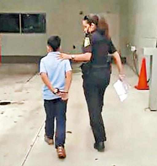 ■涉毆打教師的7歲美國男童被警察上手銬帶走。 ■涉毆打教師的7歲美國男童被警察上手銬帶走。
