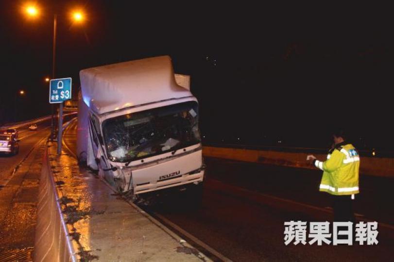 ■一輛貨車沿將軍澳隧道公路駛至近環保大道時,疑因天雨路滑失控撞壆。 ■一輛貨車沿將軍澳隧道公路駛至近環保大道時,疑因天雨路滑失控撞壆。