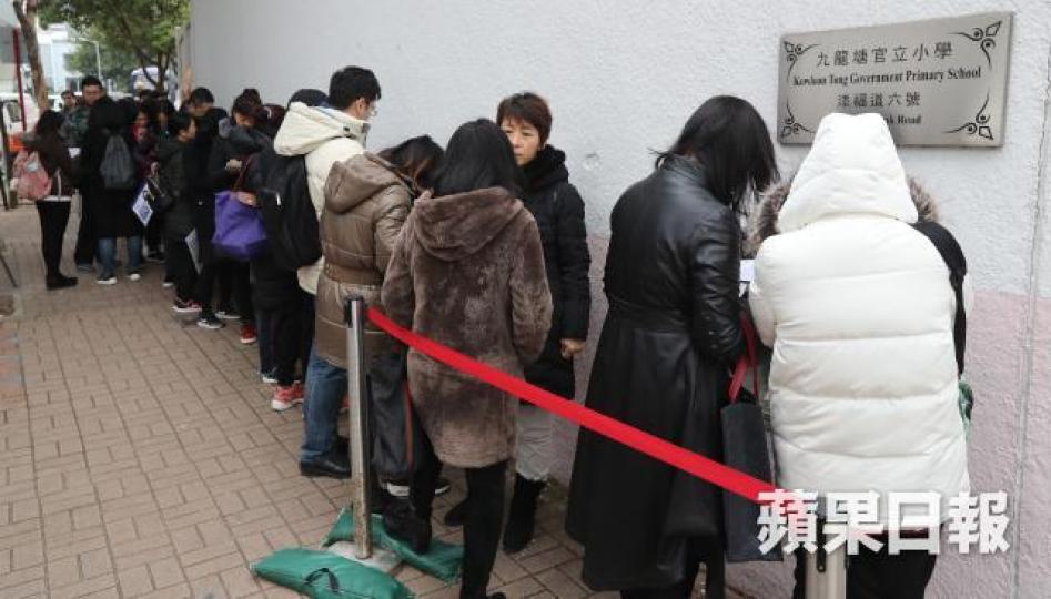 ■不少家長昨冒寒到九龍塘排隊,為子女交小一報名表。 ■不少家長昨冒寒到九龍塘排隊,為子女交小一報名表。