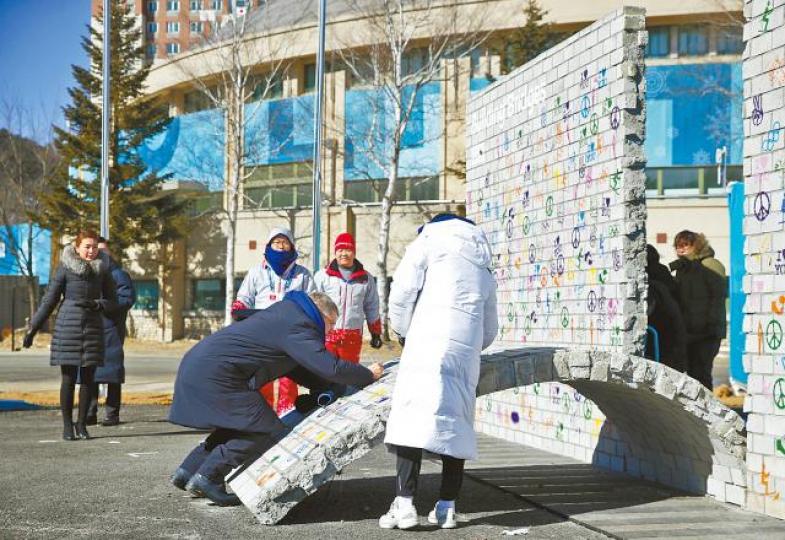 ■平昌冬奧選手村的奧運休戰壁畫昨天揭幕,國際奧委會主席巴赫在奧運休戰壁畫上簽名。美聯社
■平昌冬奧選手村的奧運休戰壁畫昨天揭幕,國際奧委會主席巴赫在奧運休戰壁畫上簽名。美聯社