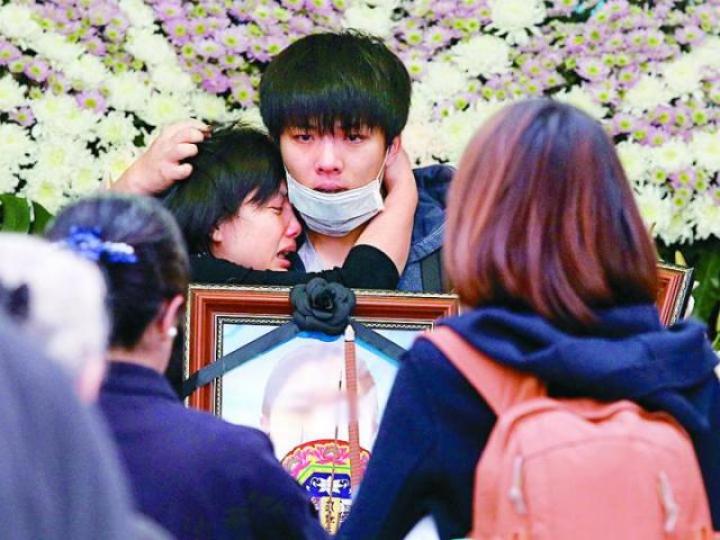 ■遇難者之一韋嘉,其親人和兒子韋思奇(中)在法會現場抱頭痛哭。
■遇難者之一韋嘉,其親人和兒子韋思奇(中)在法會現場抱頭痛哭。