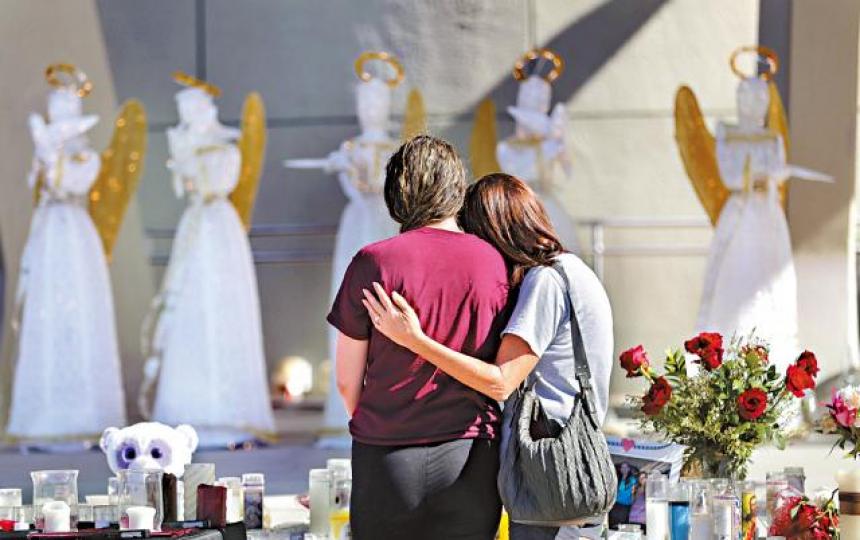 ■民眾在悼念槍擊案死者的蠟燭和鮮花前表現哀傷。 美聯社
■民眾在悼念槍擊案死者的蠟燭和鮮花前表現哀傷。 美聯社