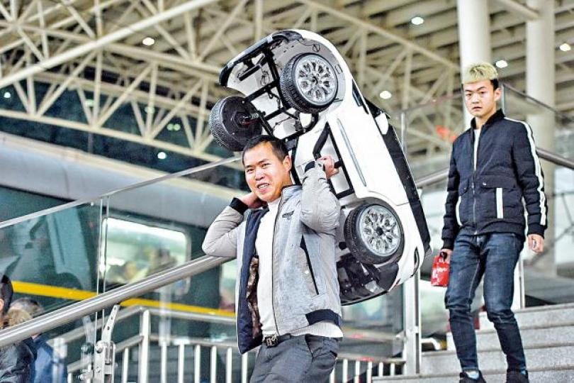 ■回程客抬着玩具車上火車。 ■回程客抬着玩具車上火車。