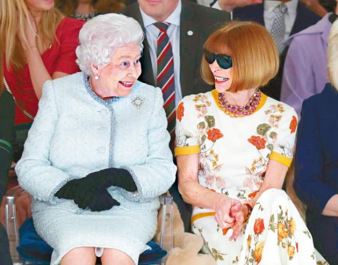 ■英女皇與「潮流教母」安娜溫特(右)並肩而坐,相談甚歡。■英女皇向Richard Quinn(左)頒發以她命名的時裝設計獎。 路透社 ■英女皇與「潮流教母」安娜溫特(右)並肩而坐,相談甚歡。■英女皇向Richard Quinn(左)頒發以她命名的時裝設計獎。 路透社