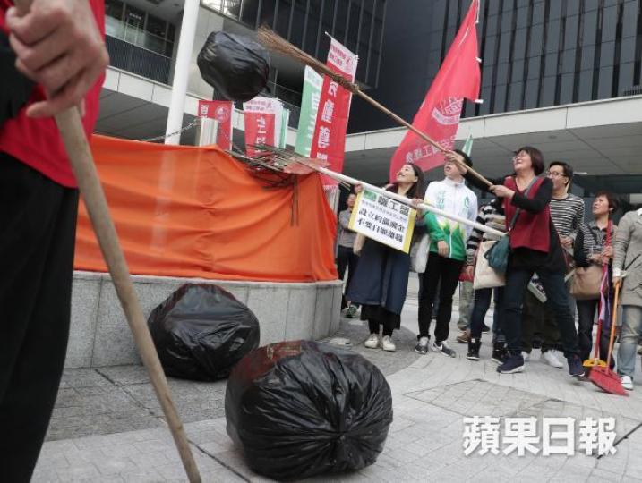 ■遊行人士將象徵外判問題的道具垃圾,掃入公民廣場欄杆內,象徵「掃畀政府」。許頌明攝 ■遊行人士將象徵外判問題的道具垃圾,掃入公民廣場欄杆內,象徵「掃畀政府」。許頌明攝