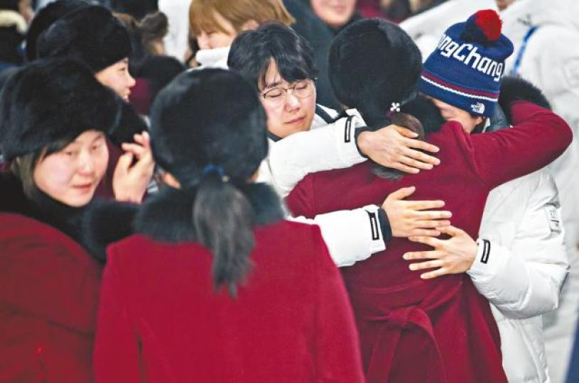 ■兩韓女子冰球聯隊的北韓隊員昨天返國前,跟穿白色外套的南韓隊友擁抱道別。美聯社 ■兩韓女子冰球聯隊的北韓隊員昨天返國前,跟穿白色外套的南韓隊友擁抱道別。美聯社