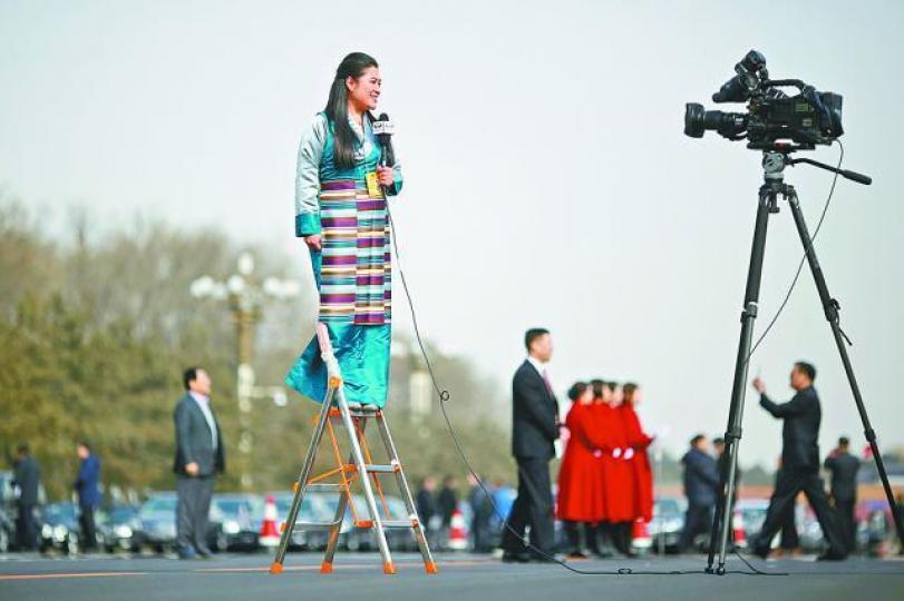 ■有女主持站在梯上「做扒」。路透社 ■有女主持站在梯上「做扒」。路透社