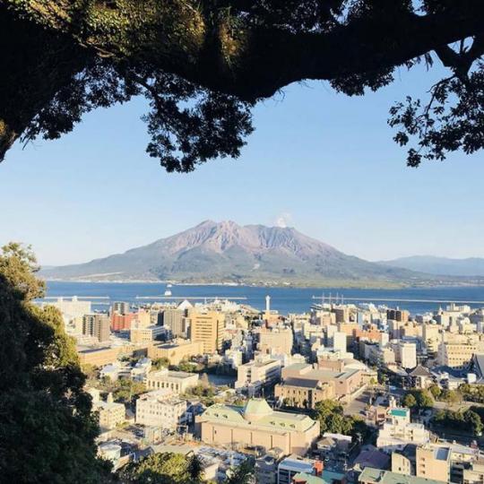 ■在城山之頂的觀景台眺望櫻島火山，就像是在欣賞着一幅巨大的立體畫。　作者提供圖片■在蔚藍錦江灣海面，櫻島火山頭上頂着朵雪白花飾隨風搖曳。　作者提供圖片