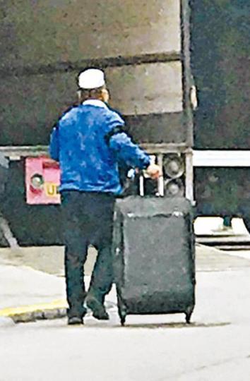 ■戴白帽的南亞賊被市民拍下拖着行李篋離去。
