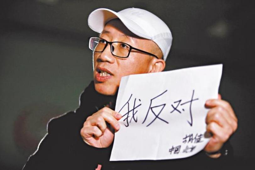 ■胡佳展示「我反對」三字，反對習修憲連任國家主席。　路透社
