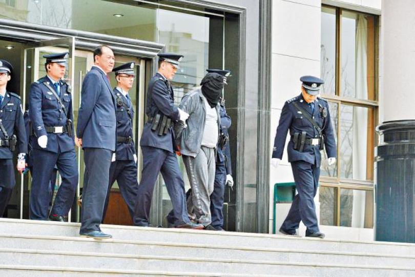 ■判刑後高承勇被黑布蒙頭帶離開法院。 ■判刑後高承勇被黑布蒙頭帶離開法院。
