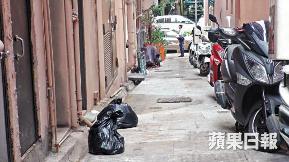 ■小白遭人掟落樓身首異處慘死,警員以兩個黑膠袋安放其遺體。張培生攝 ■小白遭人掟落樓身首異處慘死,警員以兩個黑膠袋安放其遺體。張培生攝