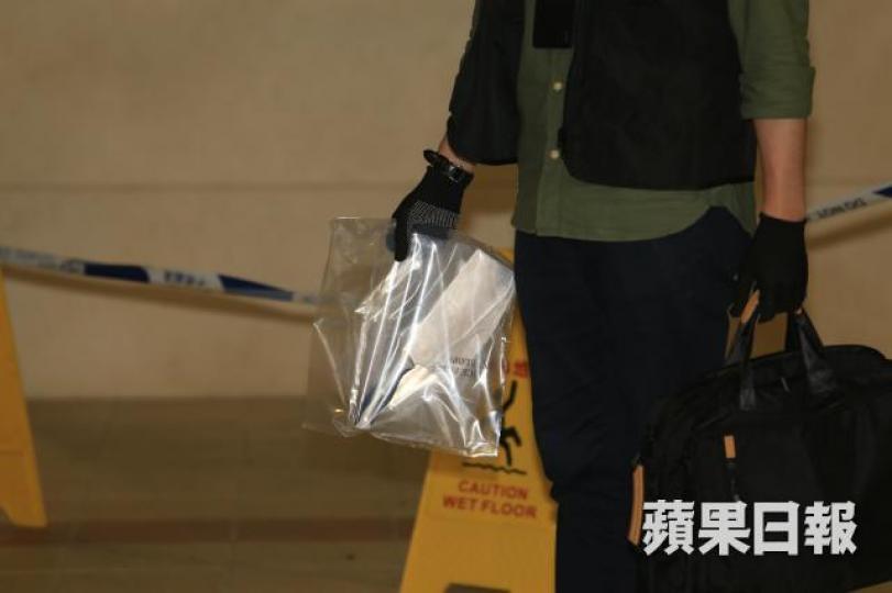 ■筲箕灣明華大廈昨發生躁女斬父案,警員撿走菜刀調查。 ■筲箕灣明華大廈昨發生躁女斬父案,警員撿走菜刀調查。