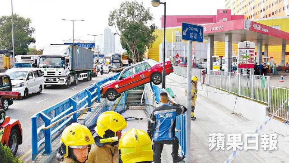 ■的士昨撞毀油站圍欄衝向行人隧道,凌空卡在隧道頂。張培生攝 ■的士昨撞毀油站圍欄衝向行人隧道,凌空卡在隧道頂。張培生攝