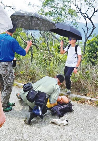 ■村巡警員接報趕至現場,為張伯施行心外壓。互聯網 ■村巡警員接報趕至現場,為張伯施行心外壓。互聯網