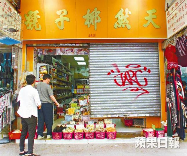 ■涉事店舖捲閘上留有被紅色噴漆噴成的英文字及符號。 ■涉事店舖捲閘上留有被紅色噴漆噴成的英文字及符號。