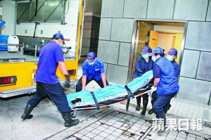 ■仵工昨將死者遺體移往殮房。 ■仵工昨將死者遺體移往殮房。