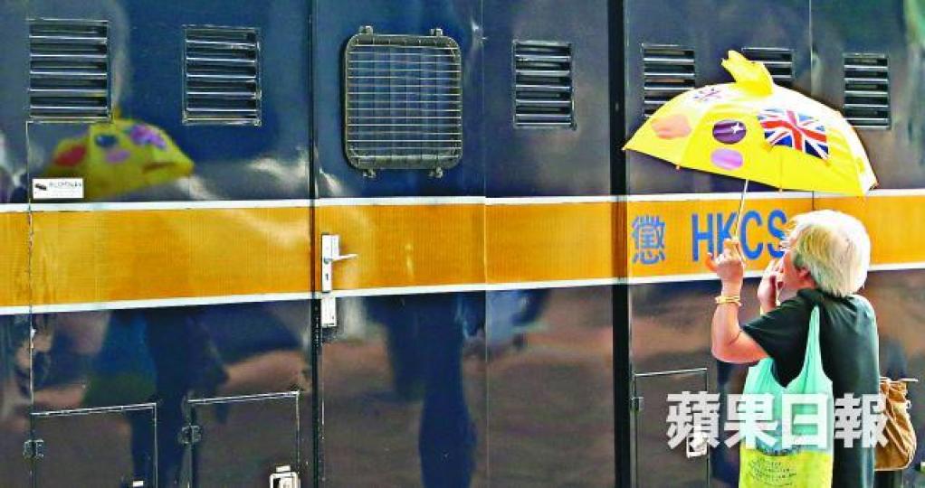 ■梁天琦昨乘囚車到庭應訊,有婆婆撐起黃傘在車外支持他。馬泉崇攝 ■梁天琦昨乘囚車到庭應訊,有婆婆撐起黃傘在車外支持他。馬泉崇攝