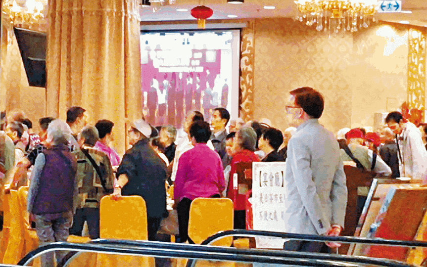 ■建制團體茶敍司儀請參加者肅立,然後播放國歌。■劉婆婆指登記參與茶敍時須填個人資料;右上為茶敍入場券。王子俊攝 ■建制團體茶敍司儀請參加者肅立,然後播放國歌。■劉婆婆指登記參與茶敍時須填個人資料;右上為茶敍入場券。王子俊攝