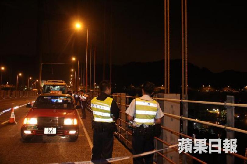 ■的士乘客下車跨越欄杆跳海,事後警員到場調查。黎志偉攝 ■的士乘客下車跨越欄杆跳海,事後警員到場調查。黎志偉攝