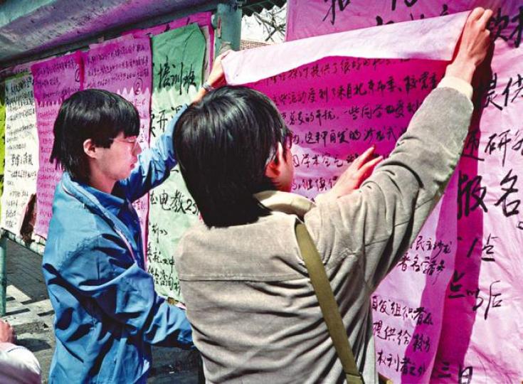 ■王丹(左)於八九學運在北大三角地貼大字報。 ■王丹(左)於八九學運在北大三角地貼大字報。