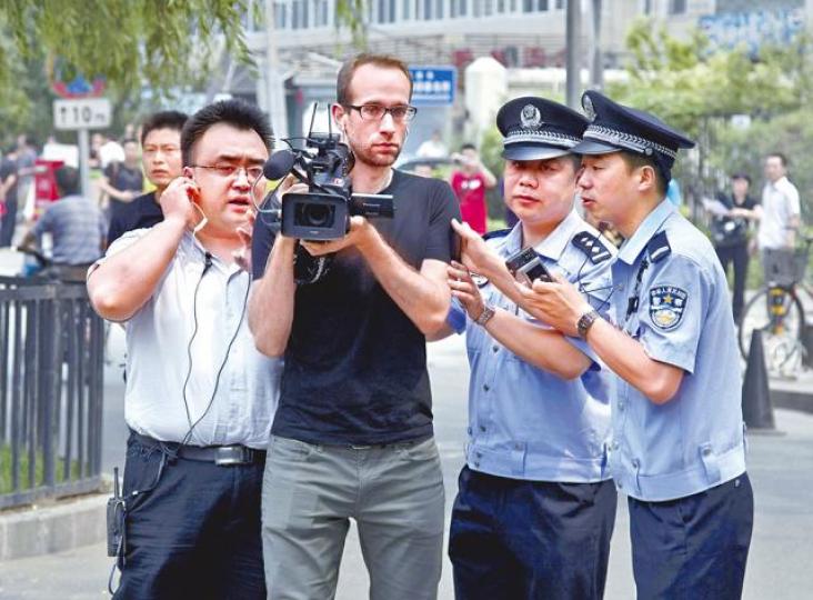 ■境外記者在內地採訪常受阻;圖為公安阻止一名外國攝影師在法庭外拍攝。 ■境外記者在內地採訪常受阻;圖為公安阻止一名外國攝影師在法庭外拍攝。