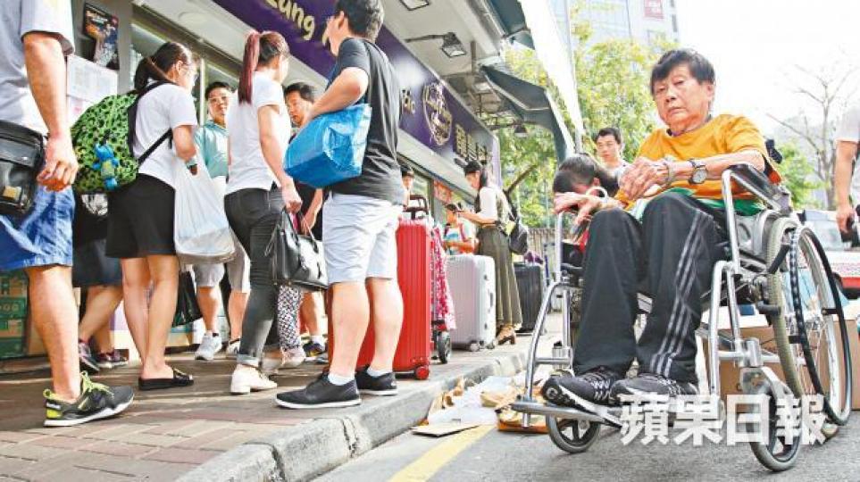 ■有坐輪椅的婆婆因行人路被行李篋阻塞而被逼出馬路。 ■有坐輪椅的婆婆因行人路被行李篋阻塞而被逼出馬路。