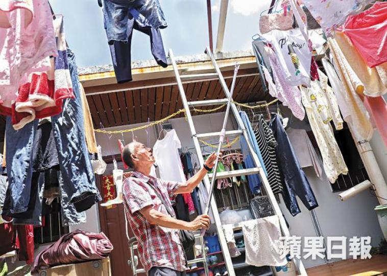 ■組合屋環境擠迫,住戶要在有蚊蟲出沒的天井晾曬衣物。王心義攝 ■組合屋環境擠迫,住戶要在有蚊蟲出沒的天井晾曬衣物。王心義攝
