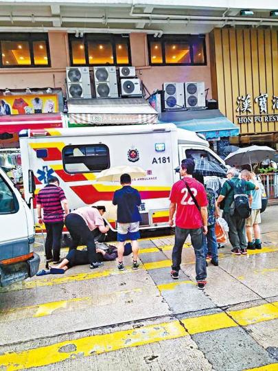 ■車禍發生後,途人上前為受傷老婦撐傘擋雨等待送院。讀者提供圖片 ■車禍發生後,途人上前為受傷老婦撐傘擋雨等待送院。讀者提供圖片