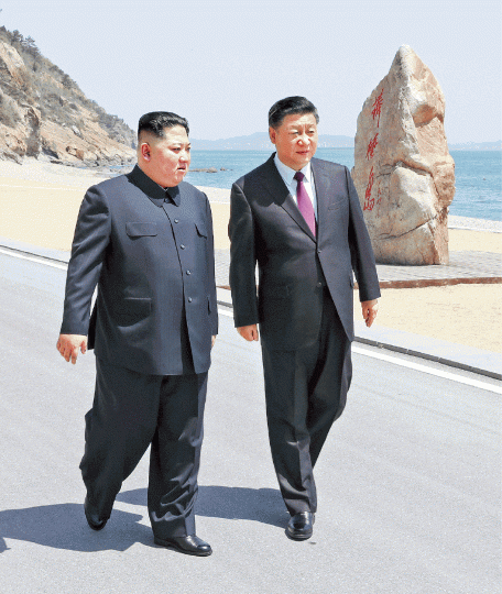 ■習近平(右)事隔40多天再與金正恩會面,兩人在大連棒棰島漫步海邊。美聯社 ■習近平(右)事隔40多天再與金正恩會面,兩人在大連棒棰島漫步海邊。美聯社