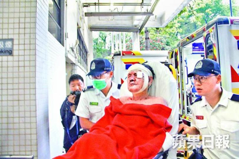 ■遇劫受傷保安員由救護員送院治療。梁澤岡攝 ■遇劫受傷保安員由救護員送院治療。梁澤岡攝