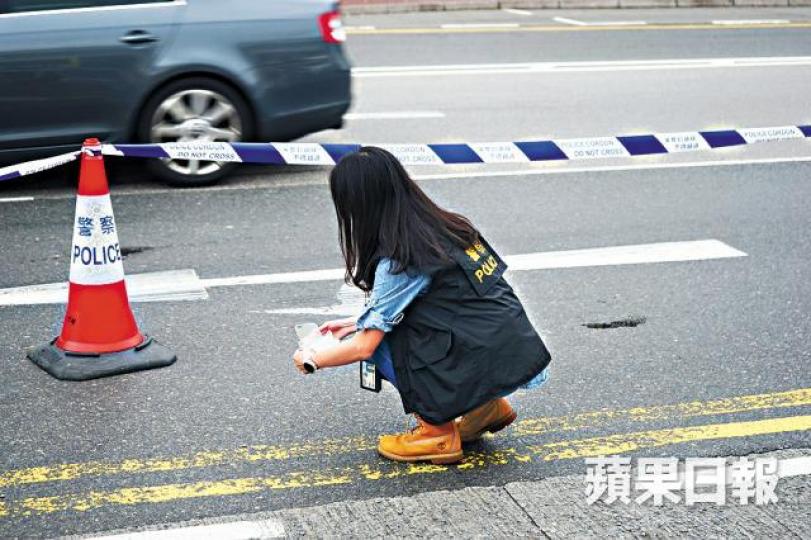 ■警員撿走遺在馬路上的手機保護殼調查。張家豪攝 ■警員撿走遺在馬路上的手機保護殼調查。張家豪攝