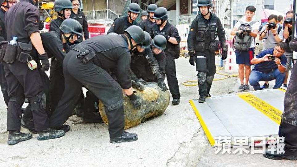 ■爆炸品處理課人員昨拆除沙中綫地盤炸彈後將彈殼運走。胡恩宏攝 ■爆炸品處理課人員昨拆除沙中綫地盤炸彈後將彈殼運走。胡恩宏攝