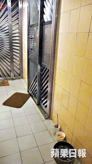■死者單位外昨仍擺放着香燭祭品。張培生攝 ■死者單位外昨仍擺放着香燭祭品。張培生攝