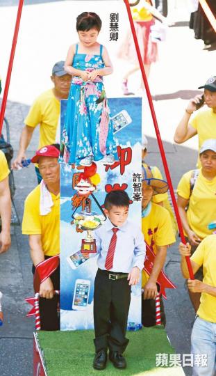 ■名為「卿峯作浪」的飄色以立法會議員許智峯搶手機為題,小演員分別扮演劉慧卿及許智峯。王子俊攝■飽受批評的財政司長陳茂波成為今年的重點角色。■為表揚本地運動員貢獻,單車手李慧詩及桌球運動員吳安儀亦成為扮演對象。王心義攝■昨最高氣溫逾34℃,扮演皇帝(左圖)及電視劇角色周瑩(右圖)的小演員需手執風扇及吃雪糕降溫。 ■名為「卿峯作浪」的飄色以立法會議員許智峯搶手機為題,小演員分別扮演劉慧卿及許智峯。王子俊攝■飽受批評的財政司長陳茂波成為今年的重點角色。■為表揚本地運動員貢獻,單車手李慧詩及桌球運動員吳安儀亦成為扮演對象。王心義攝■昨最高氣溫逾34℃,扮演皇帝(左圖)及電視劇角色周瑩(右圖)的小演員需手執風扇及吃雪糕降溫。