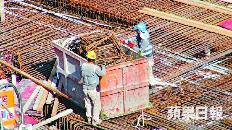 ■地盤工人以夾斗把不合規格鋼筋搬上貨車再運走。資料圖片